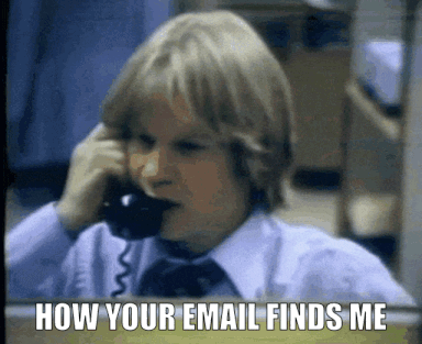 Animated gif of a 1979s era person in a busy rooming answering two phones at the same time. 