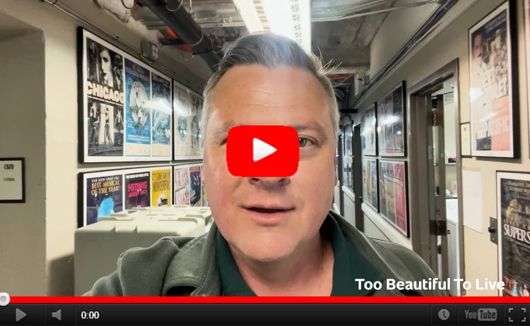 YouTube still image of Luke in a hallway covered in production posters (backstage at a theater)