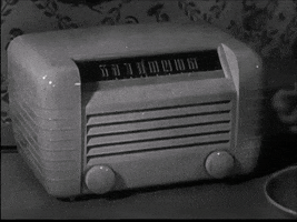 Animated gif of someone twisting a knob back and forth on  a vintage radio. 