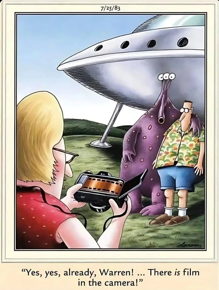 Far Side cartoon showing a woman exposing the film in her camera while taking a photo of her husband with an alien and its spaceship. Caption says "Yes Yes already, Warren, there is film in the camera"