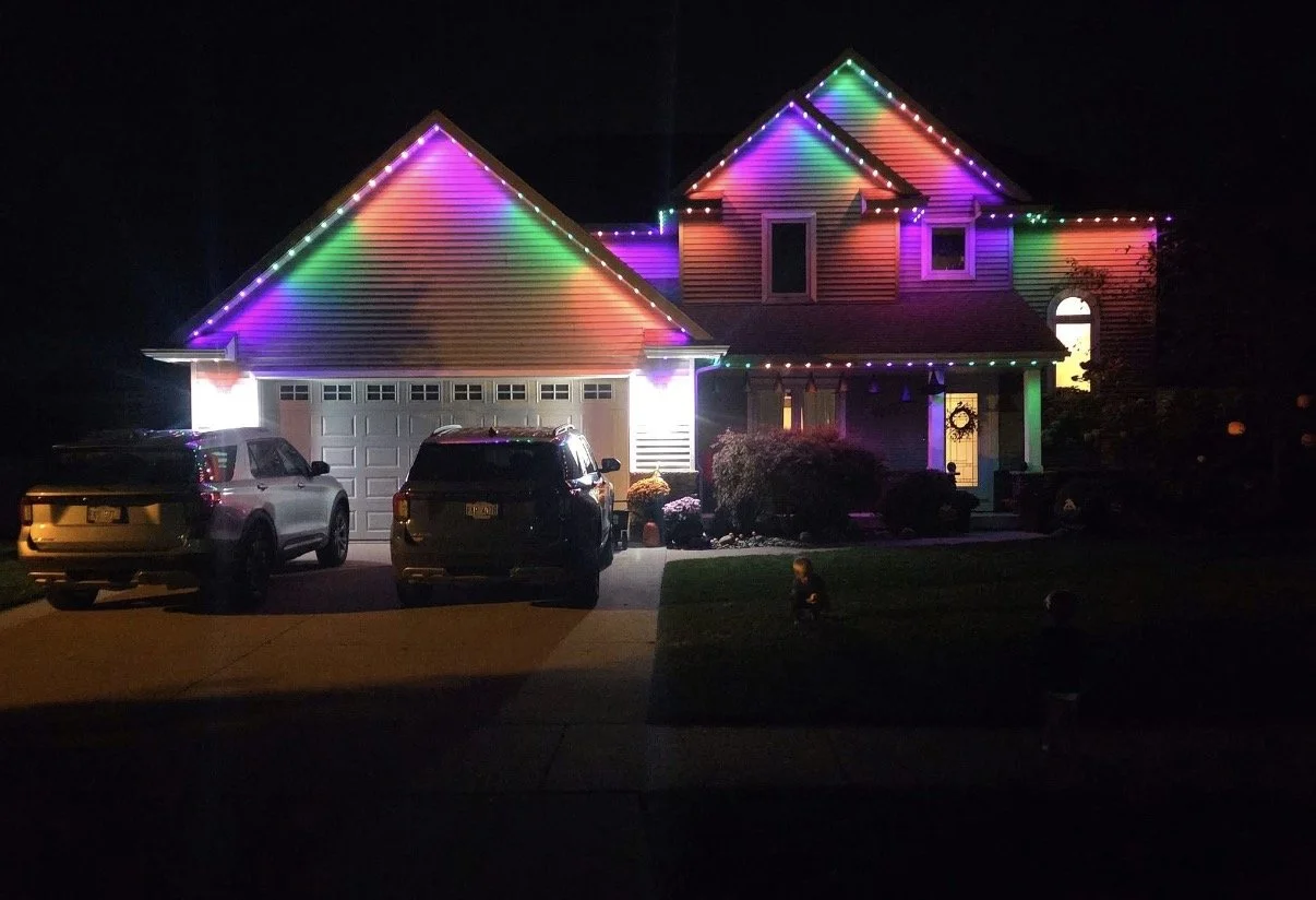 Colorful Minleon permanent roofline lighting installed by Tri-City Lighting on a two-story home