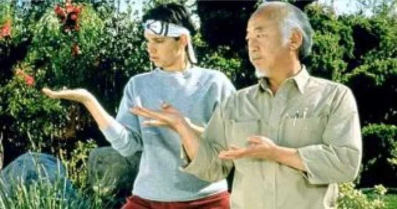Mr. Miyagi teaches Daniel karate in a freeze frame from the film The Karate Kid.