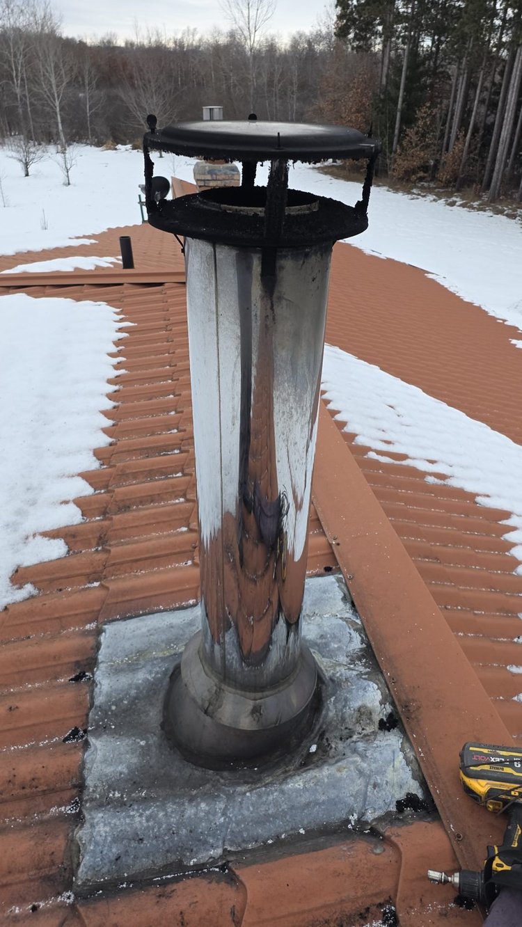 The heater's stainless chimney coming through a metal roof in the snow
