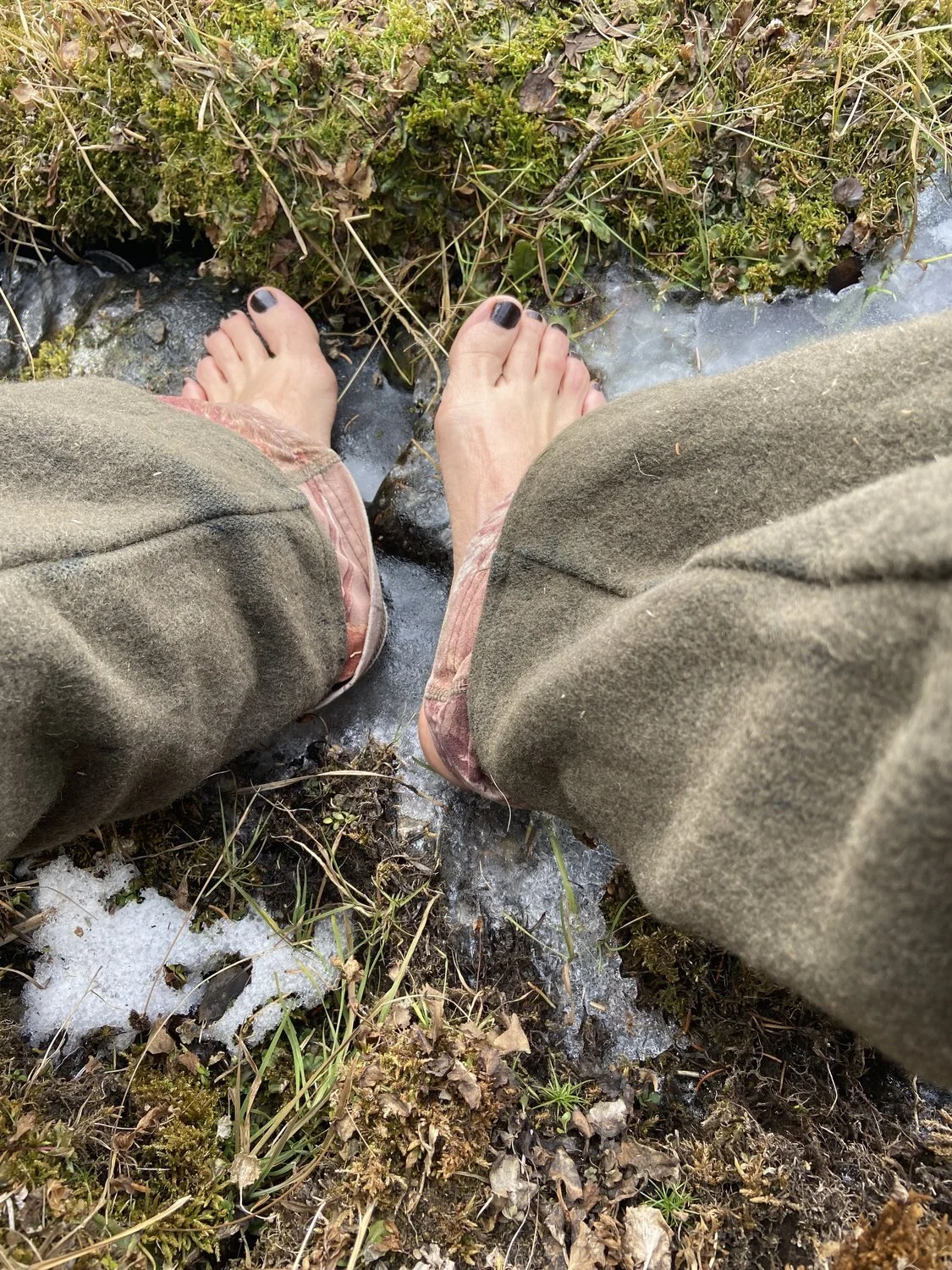 Christie Green’s bare feet in an icy creek.