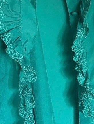 Embroidered eyelet ruffle on the placket of the blouse.