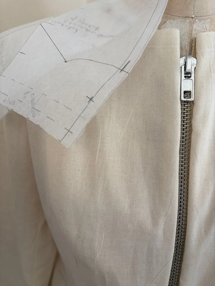 A zipper set into a muslin bodice.