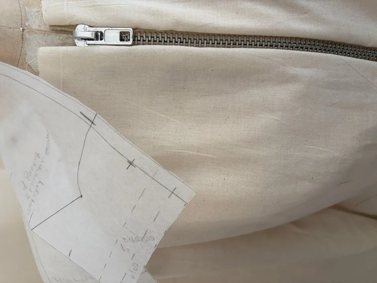 A zipper set into a muslin bodice.