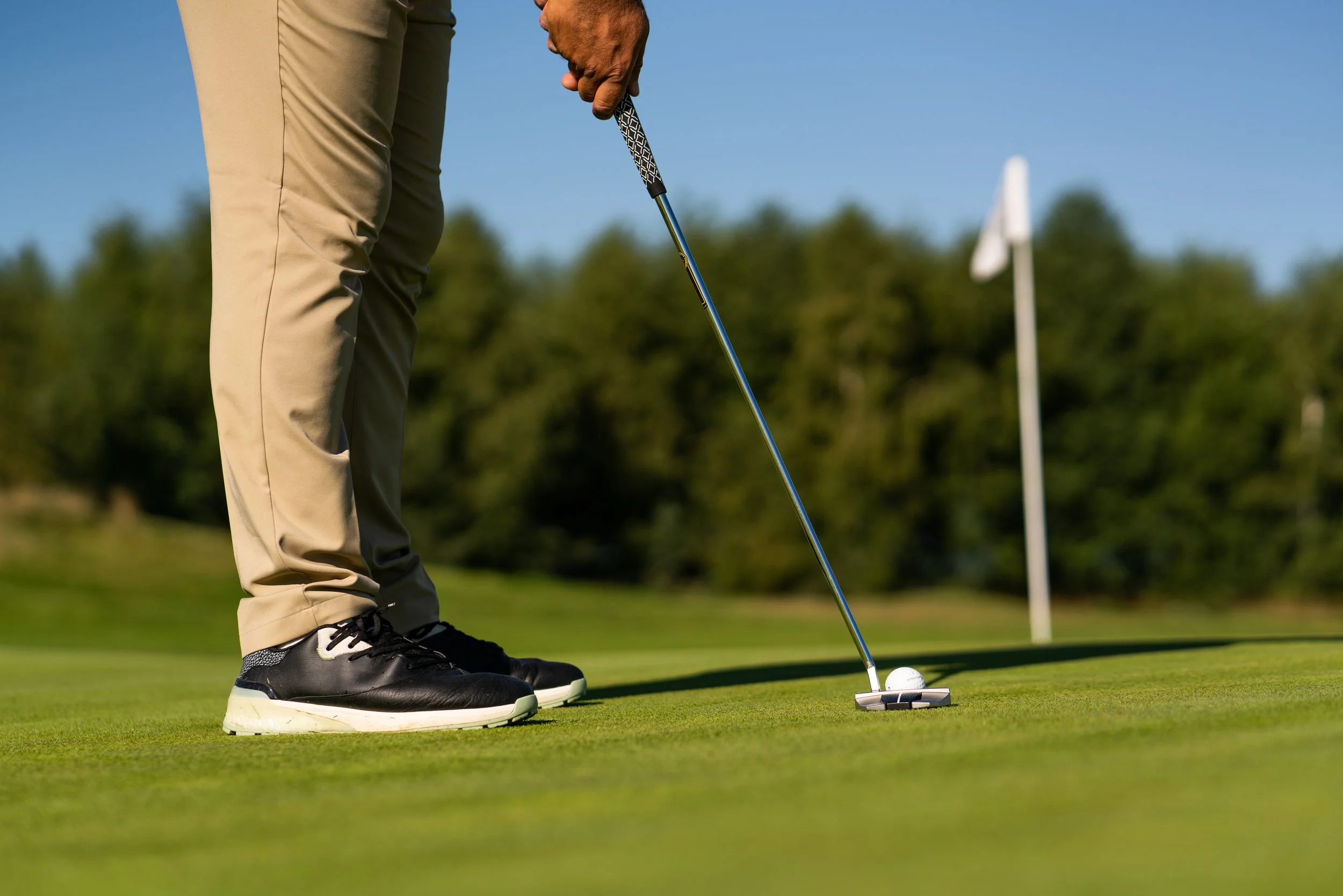 Golfista przygotowujący putt do dołka na greenie