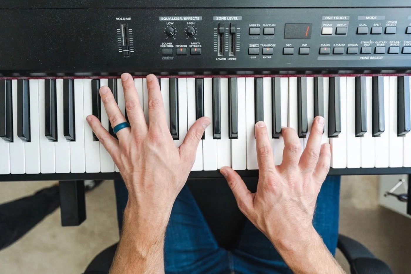 Hands playing worship chords on a keyboard