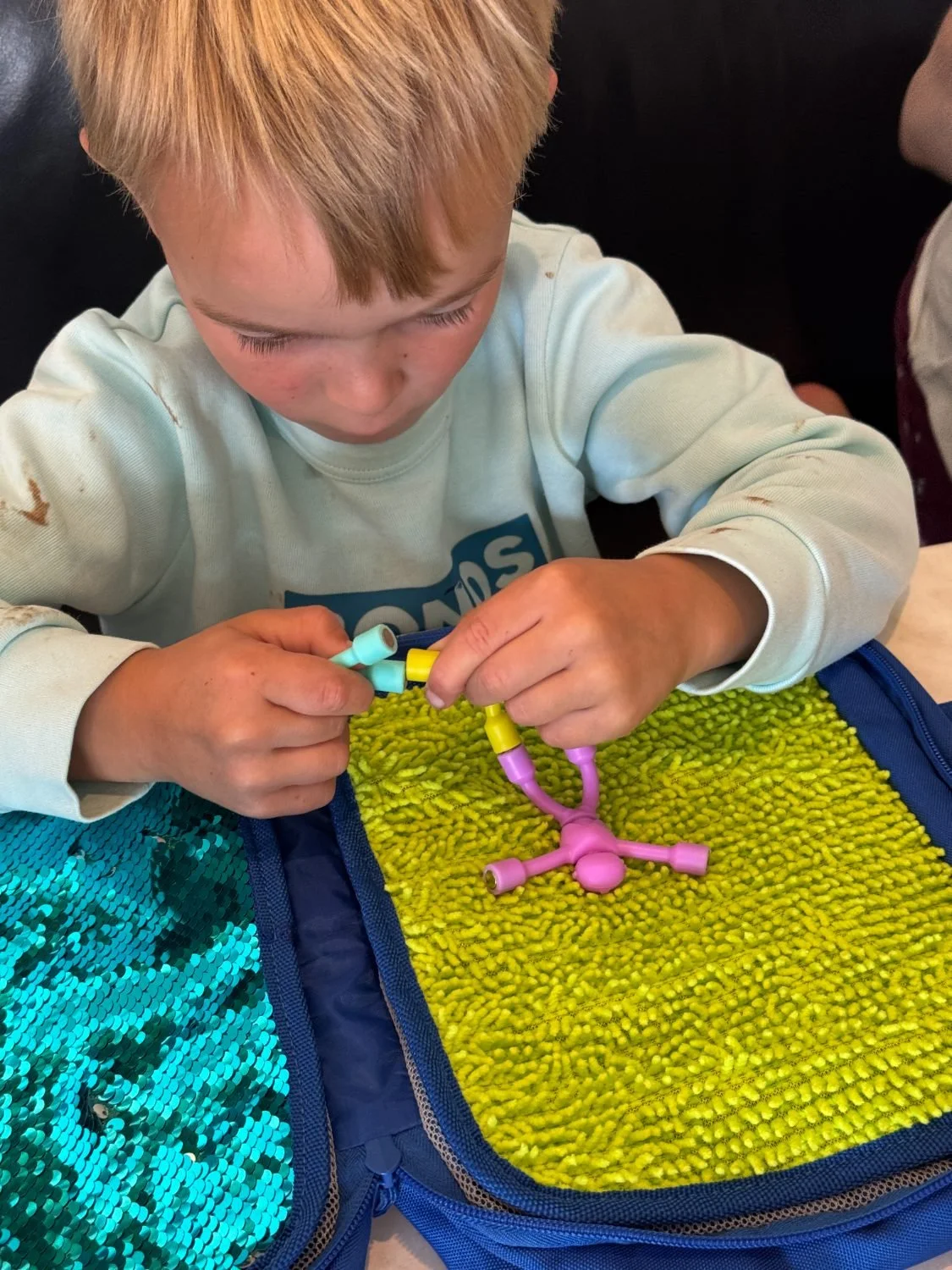 A child playing with magnet people on the textured sensory panel