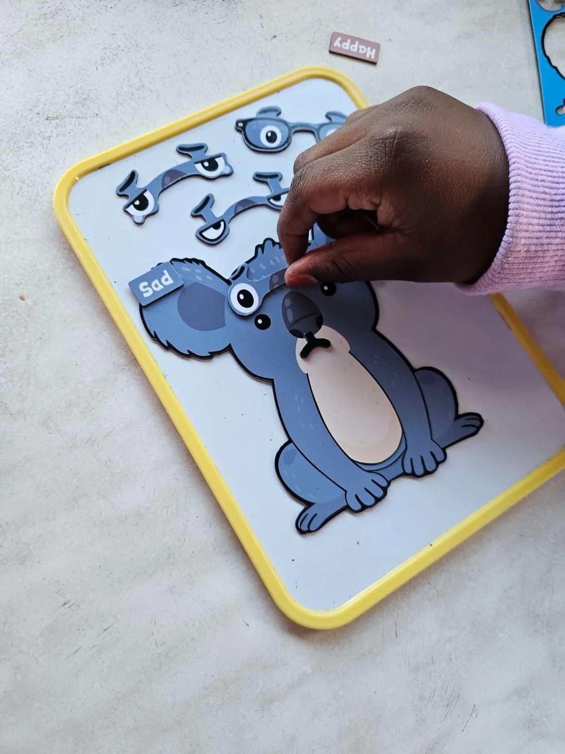 A child building a feeling face on the Aussie animal emotion magnet sheet