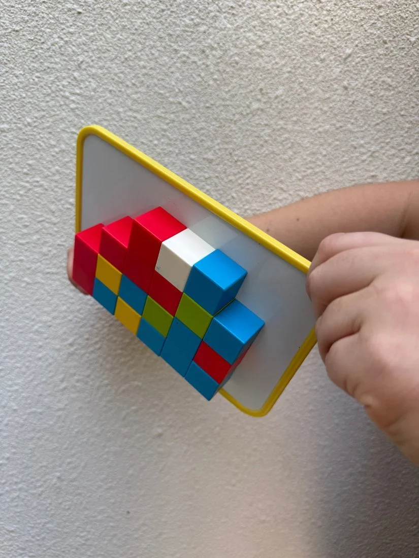 Magnetic cubes held in place on the whiteboard as it tilts