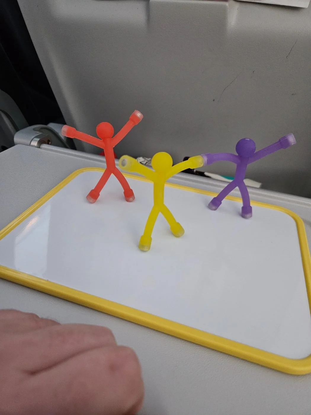 Magnet people standing on the whiteboard on a plane tray table