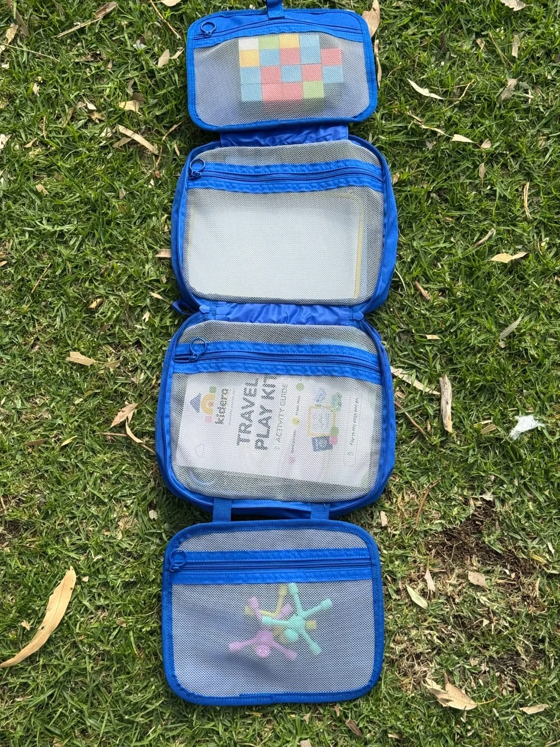 The Kidera Travel Play Kit unfolded, showing its zip pockets