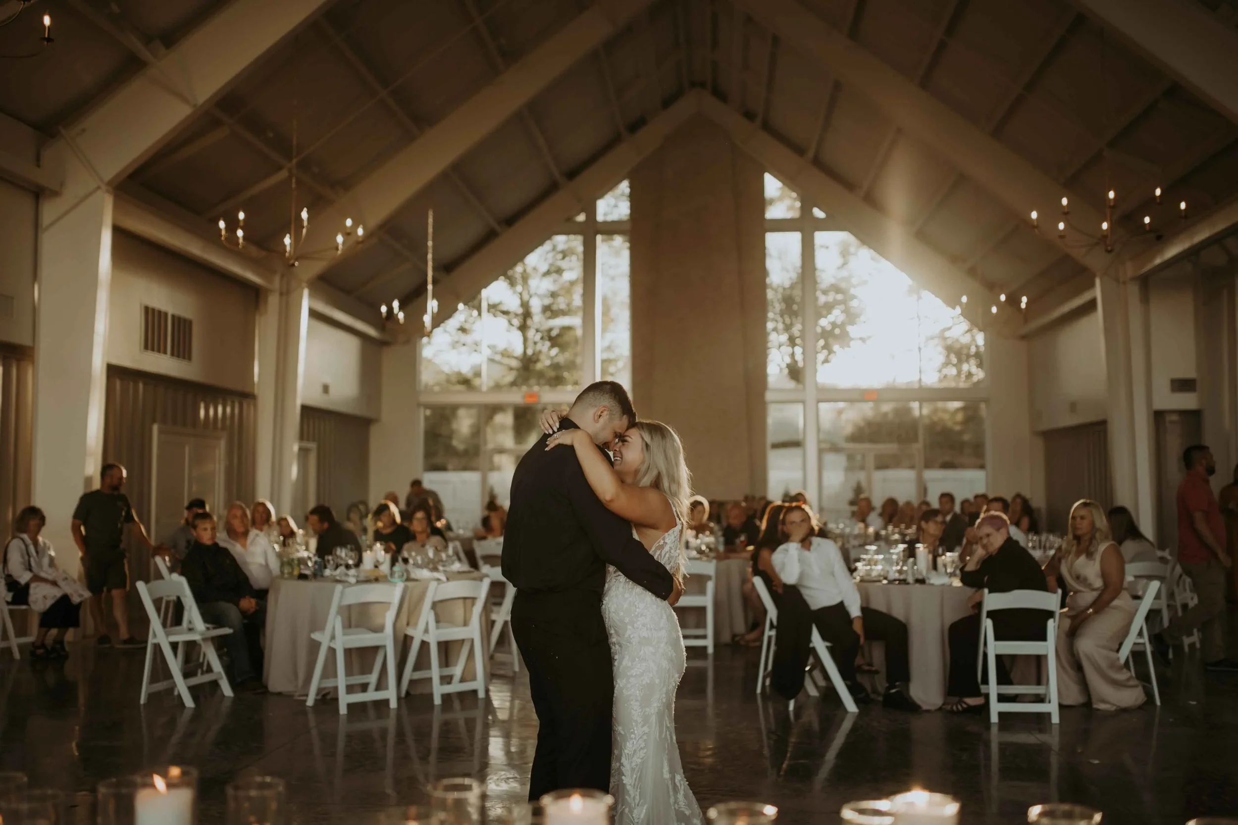 Newlyweds sharing their first dance in a bright modern reception hall