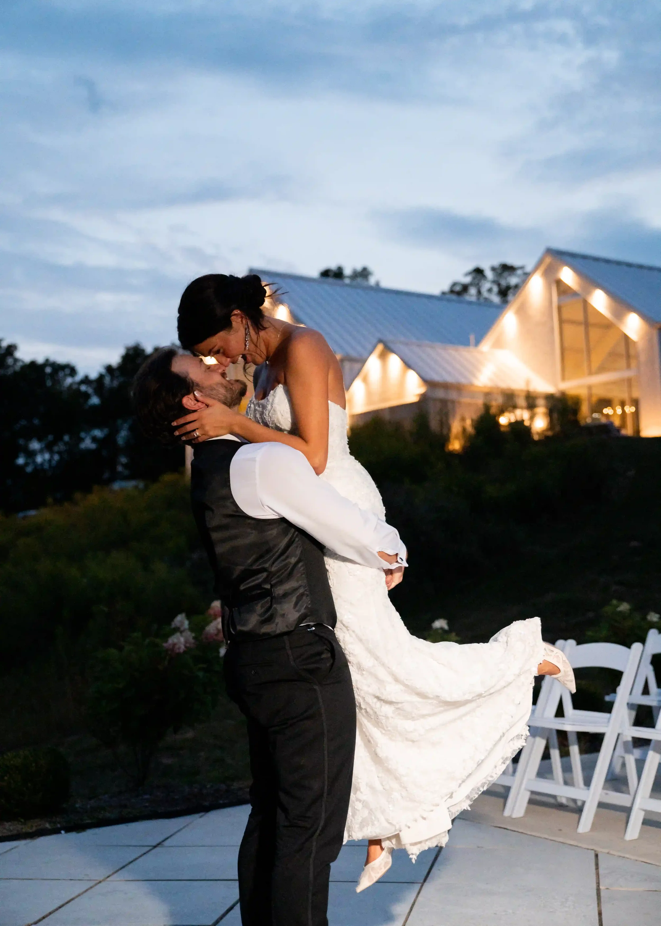 Couple sharing a romantic evening dance outside the illuminated venue