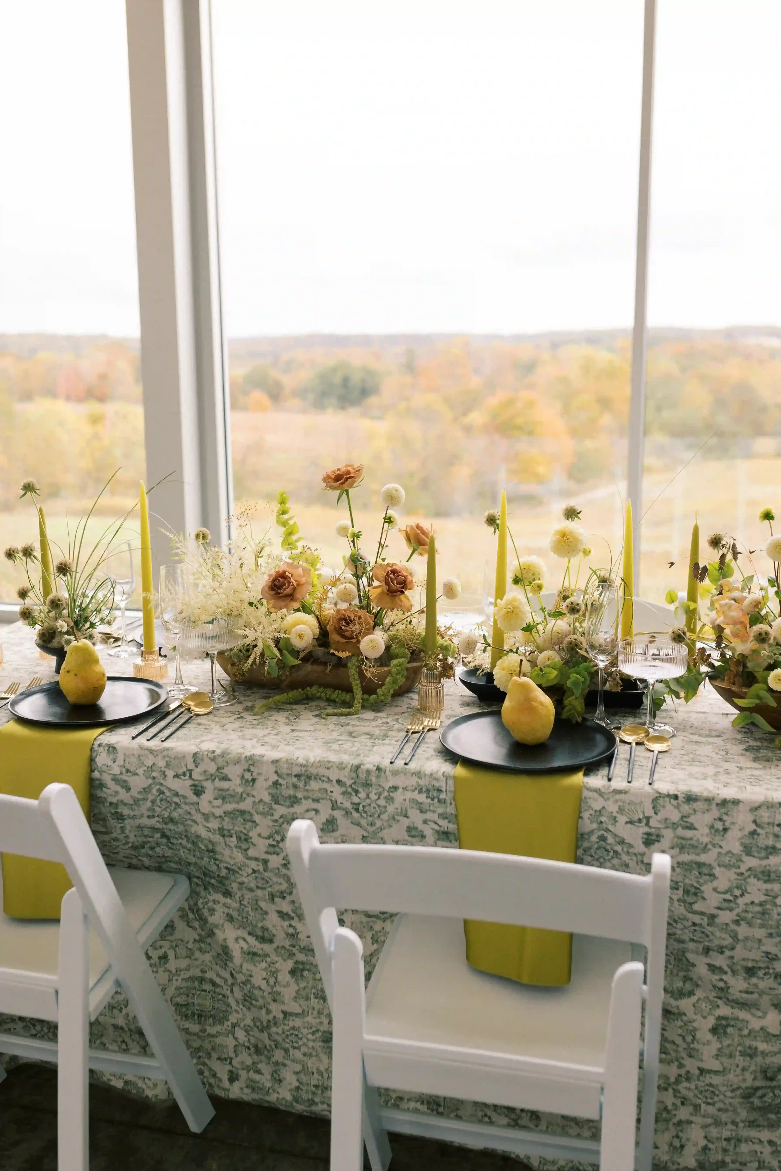 Reception tablescape with florals, candles, and panoramic countryside views
