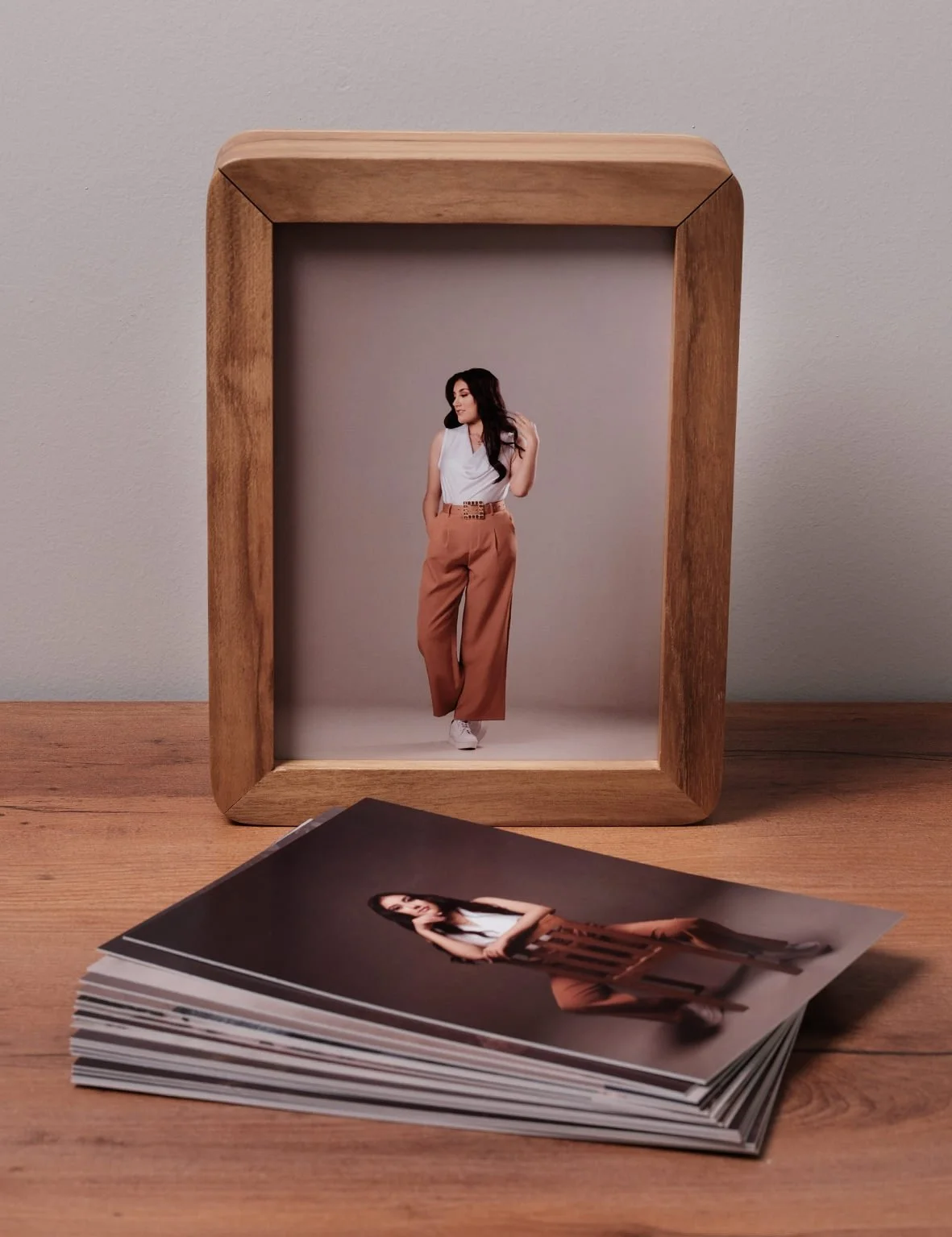 Caja de madera utilizada como portarretratos, junto a las fotografías impresas de la colección