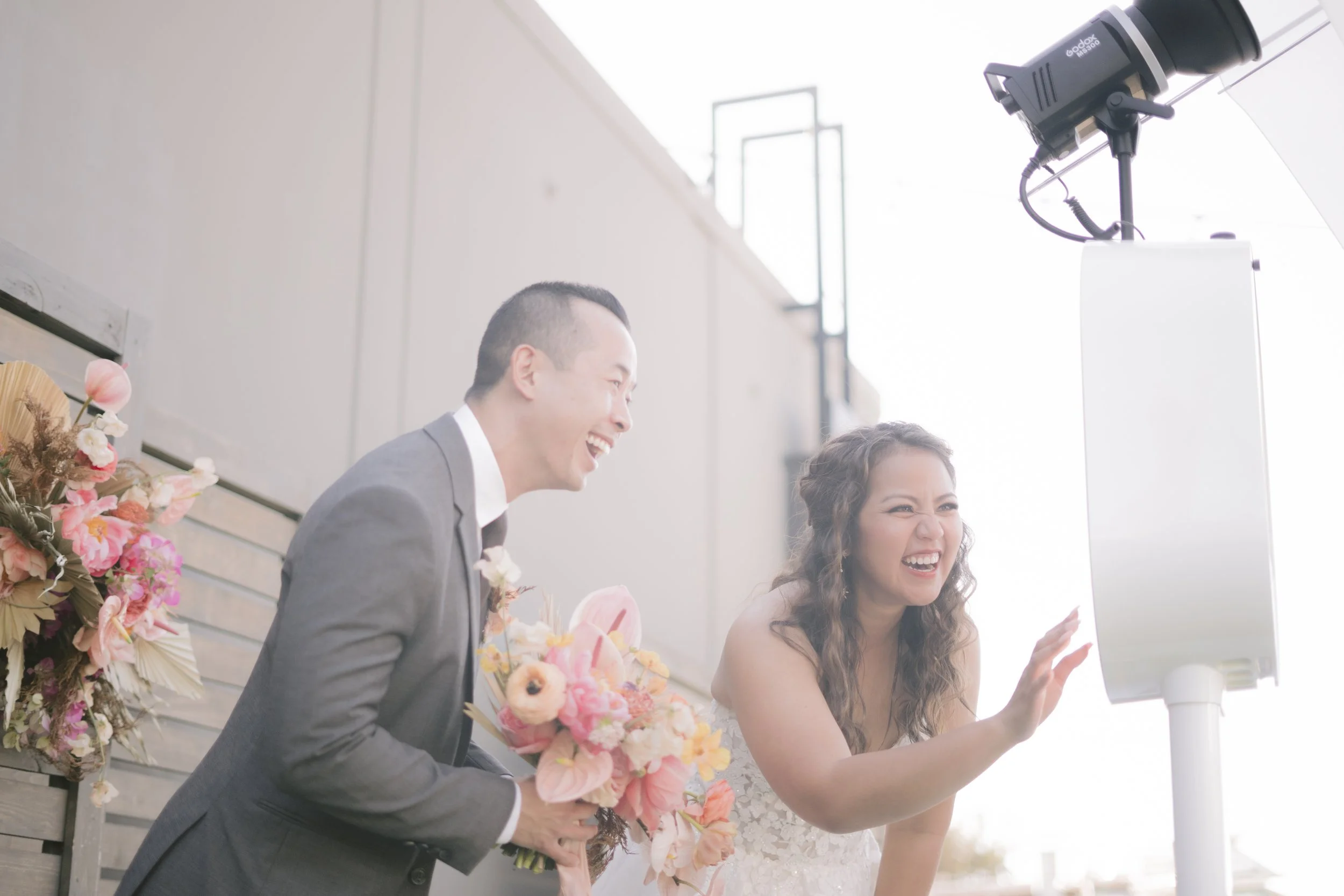 Guests laughing and posing at an Auckland wedding photo booth