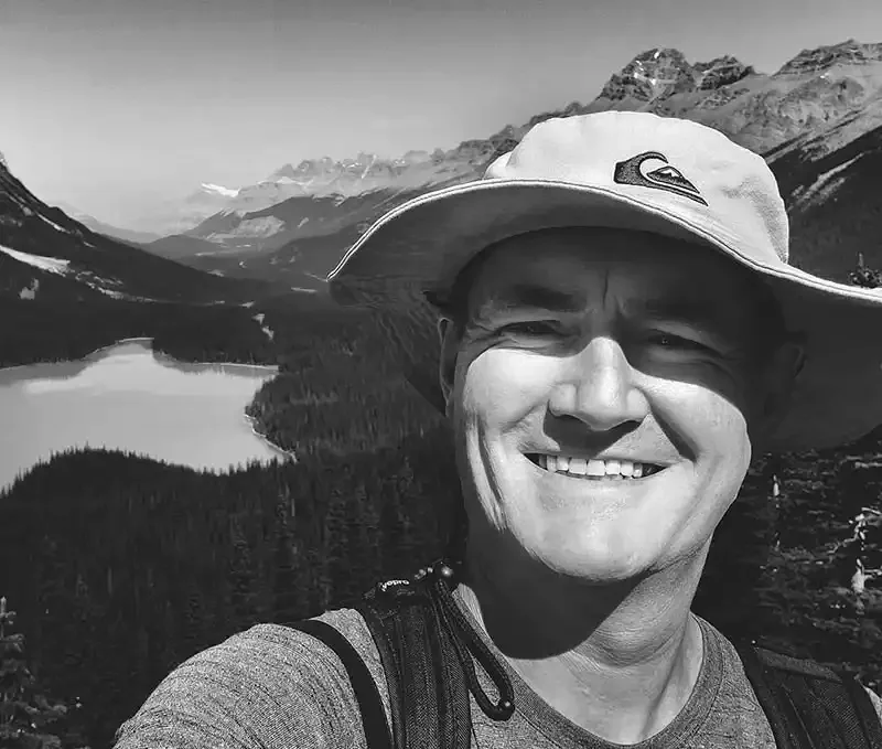 Vaughn Barry smiling in front of a mountain lake