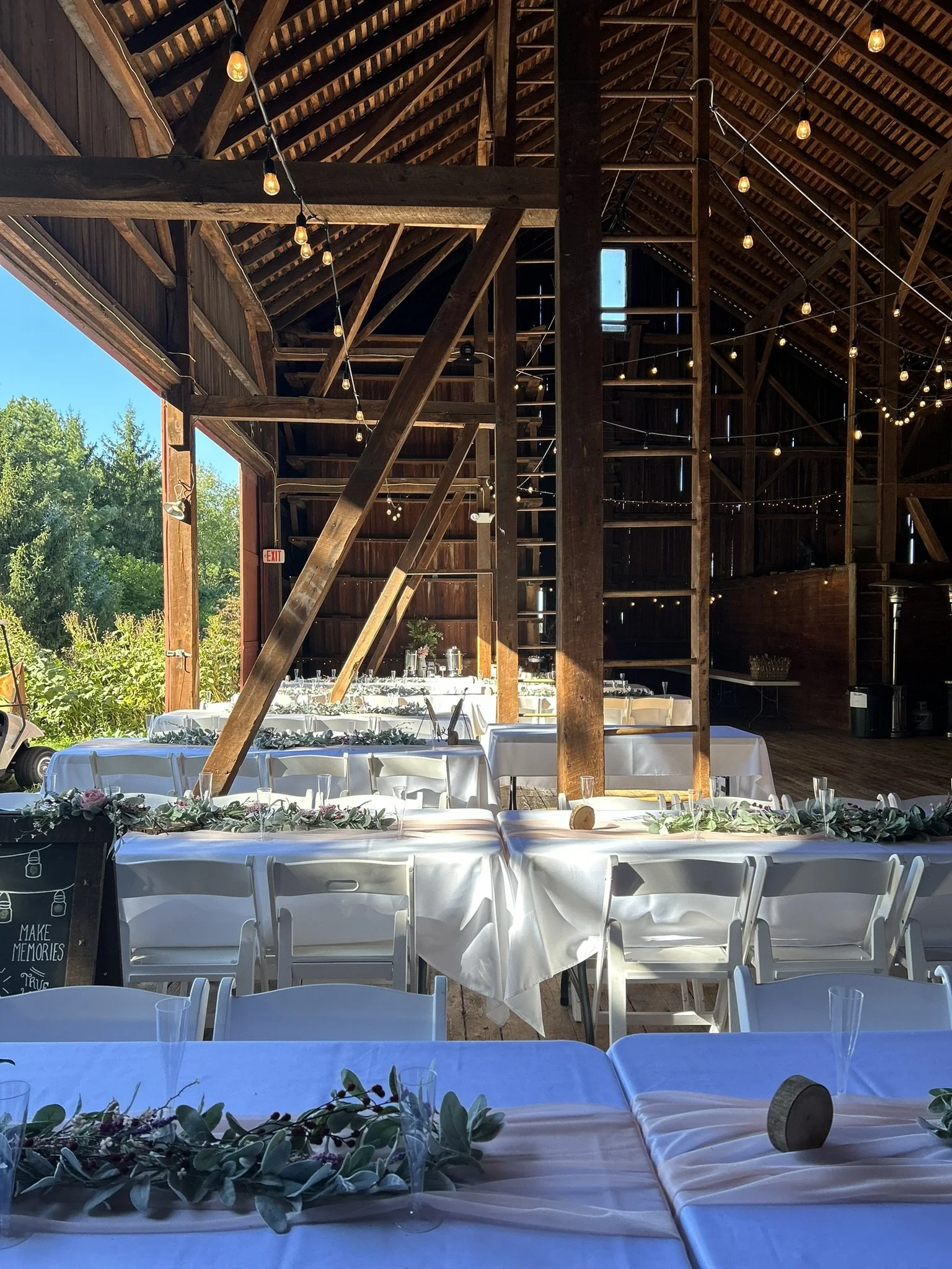 Interior view of the rustic wooden beams, edison lighting and open air in the barn at Crown Point