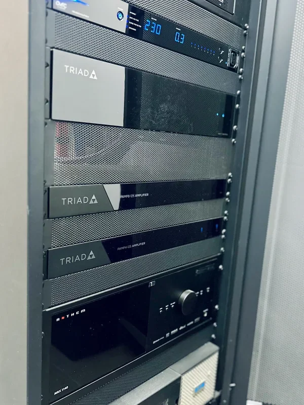 Wzmacniacze Triad i urządzenia audio w szafie domu modelowego