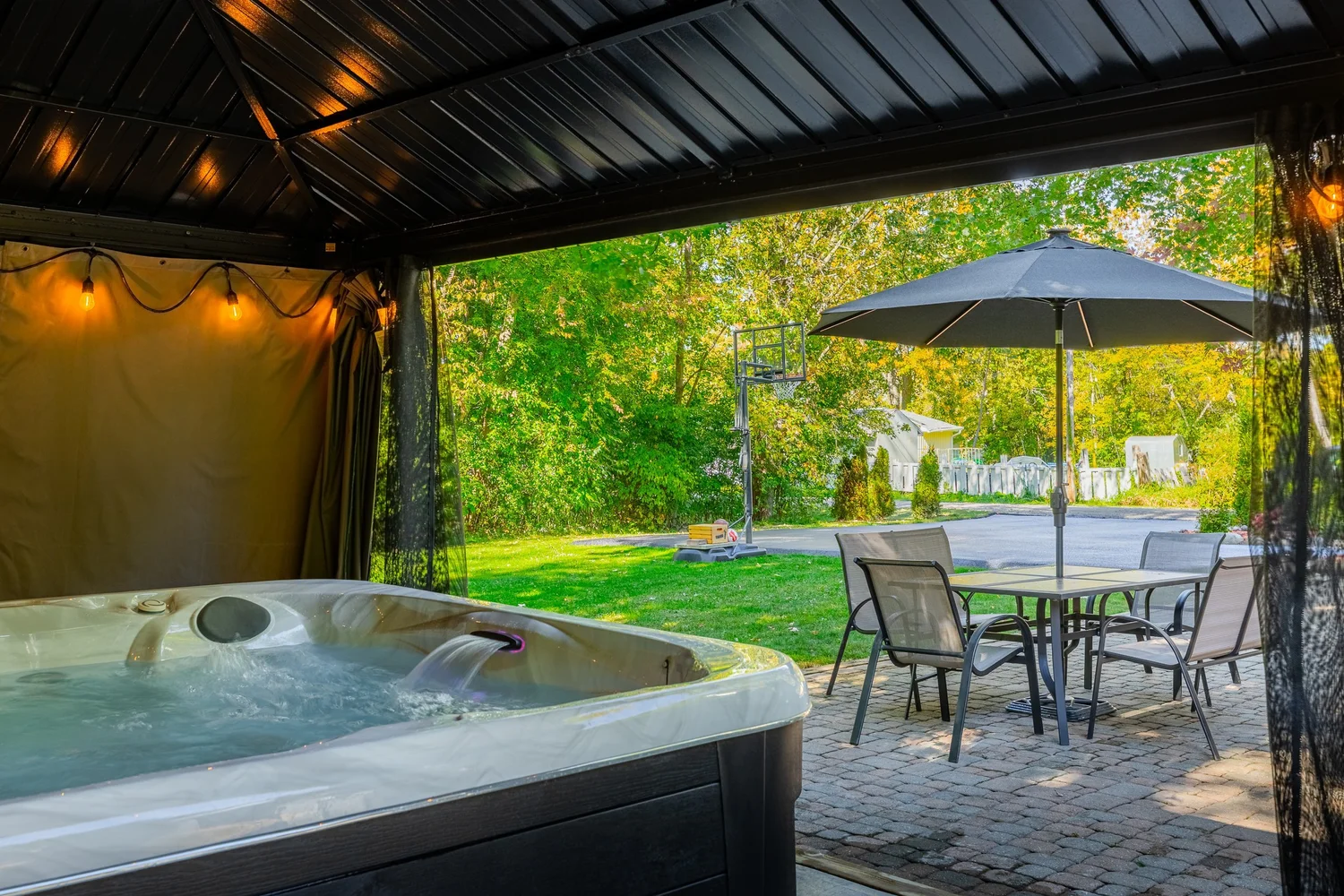 Backyard patio with hot tub under a covered gazebo