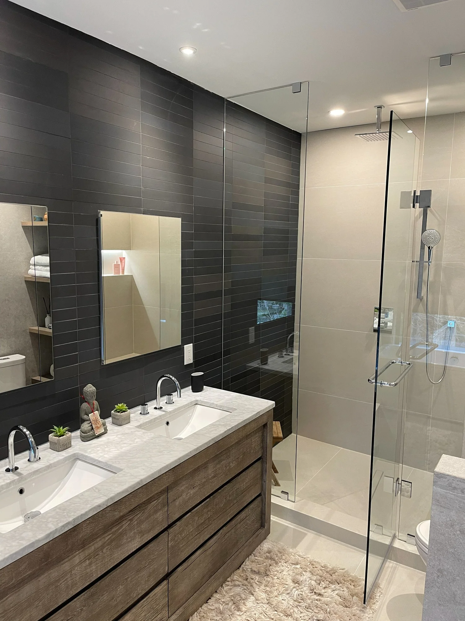 Spa-style ensuite with a dark feature wall, double vanity and glass shower