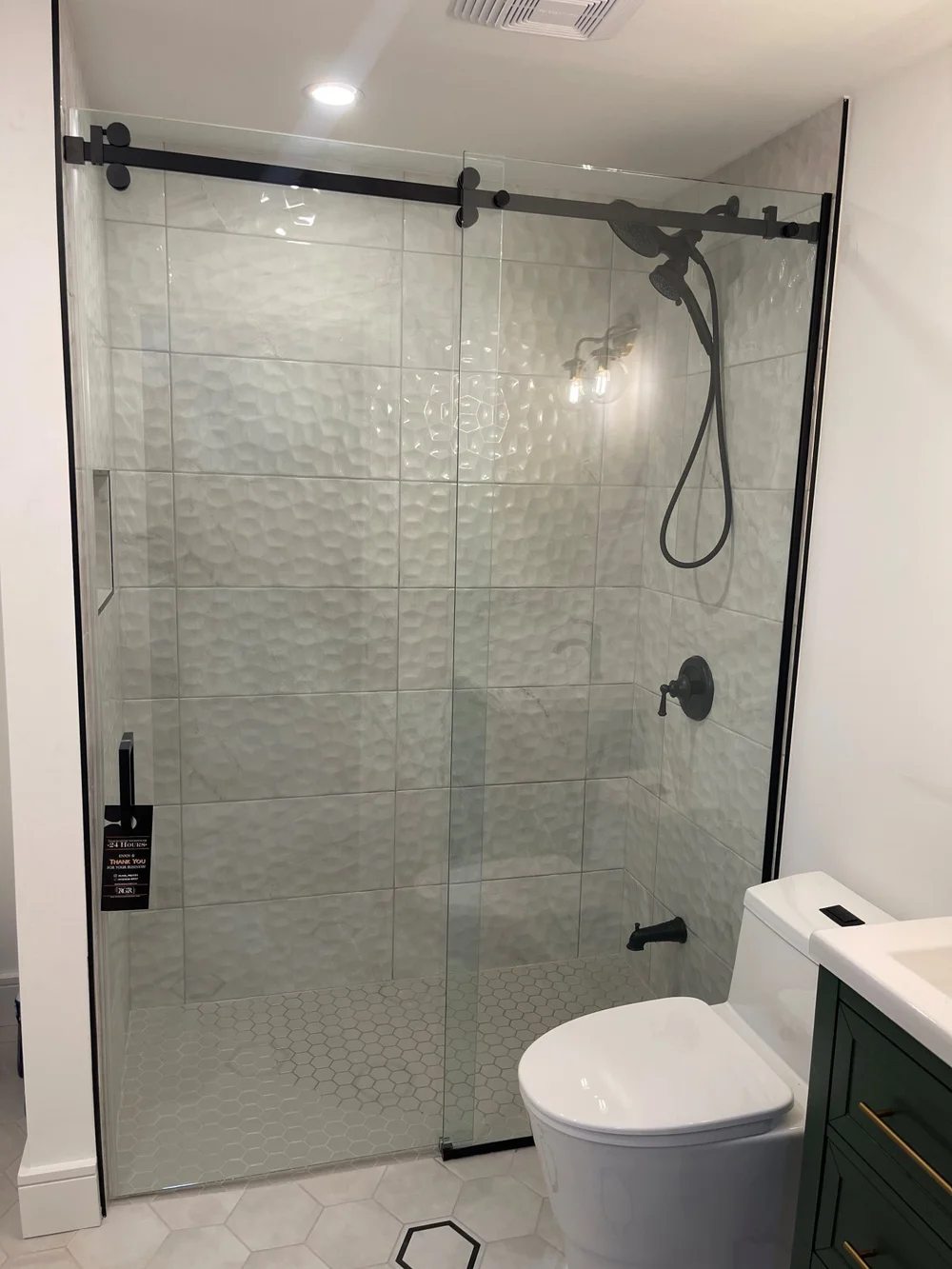 3D wall tile and matte black shower fixtures in the renovated Etobicoke bathroom