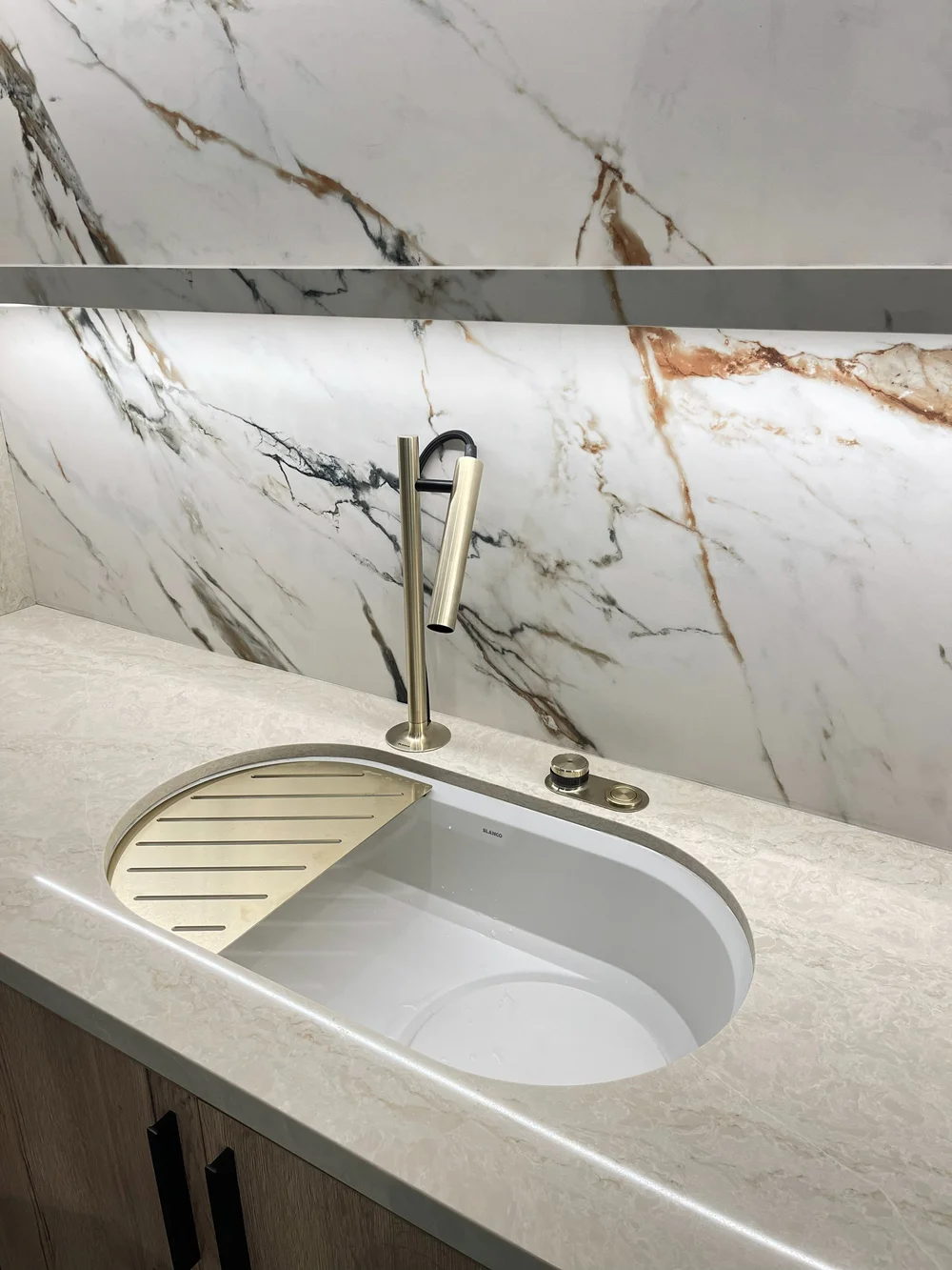 Sink station with a marble-look stone backsplash at the Caesarstone showroom