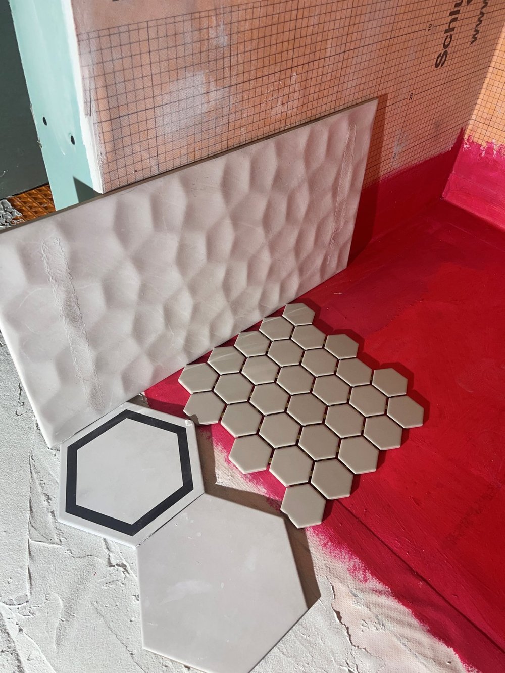 3D wall tile and hexagon floor tile samples laid out in the Etobicoke bathroom