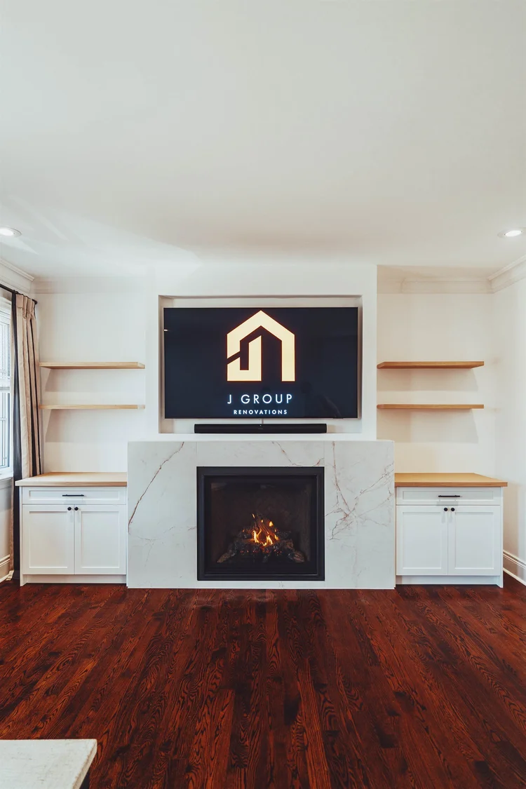 Living room fireplace feature wall with slab surround, built-ins and floating oak shelves