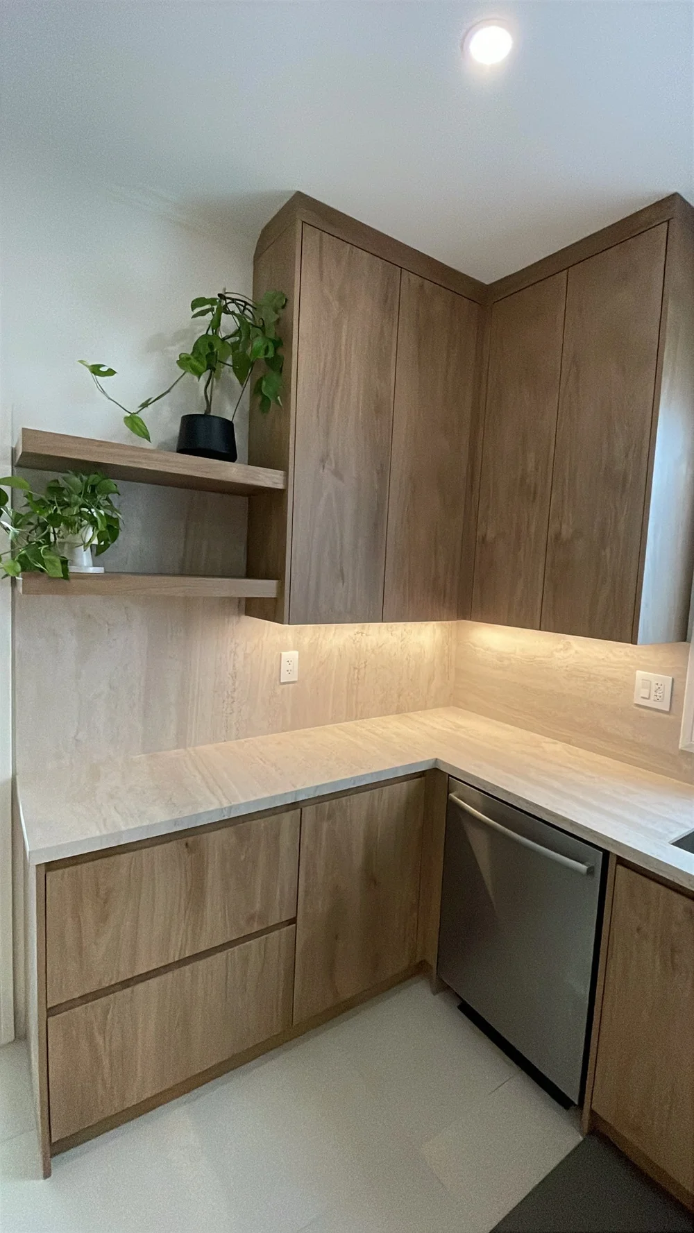 Corner cabinets with under-cabinet lighting and floating shelves in a Leslieville kitchen