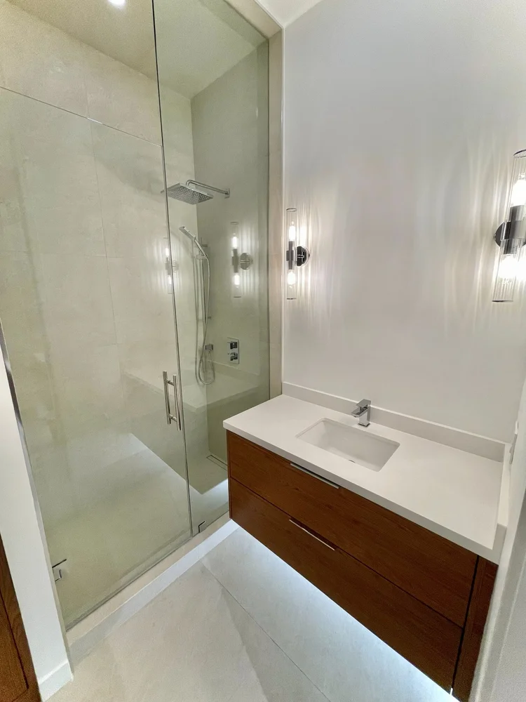 Loft bathroom at Toy Factory Lofts with walnut vanity and frameless glass shower