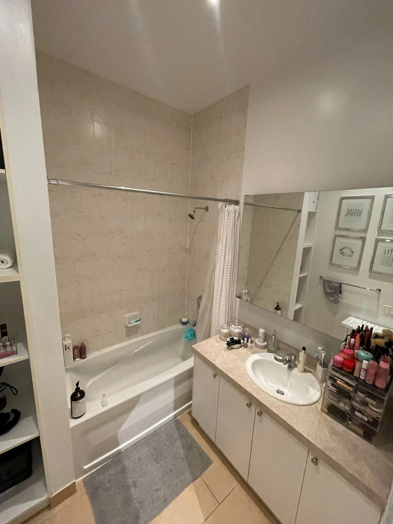 Toy Factory Lofts bathroom before the renovation, with a tub, shower curtain and long white vanity