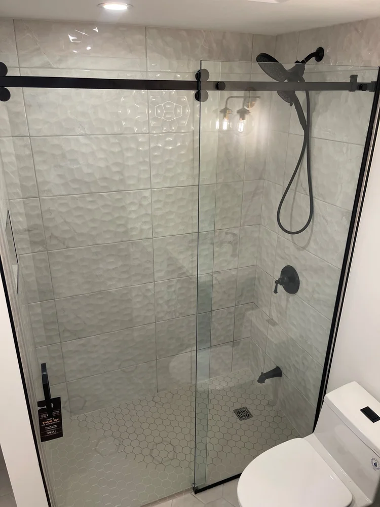 Etobicoke bathroom with sliding glass shower, 3D wall tile and black fixtures