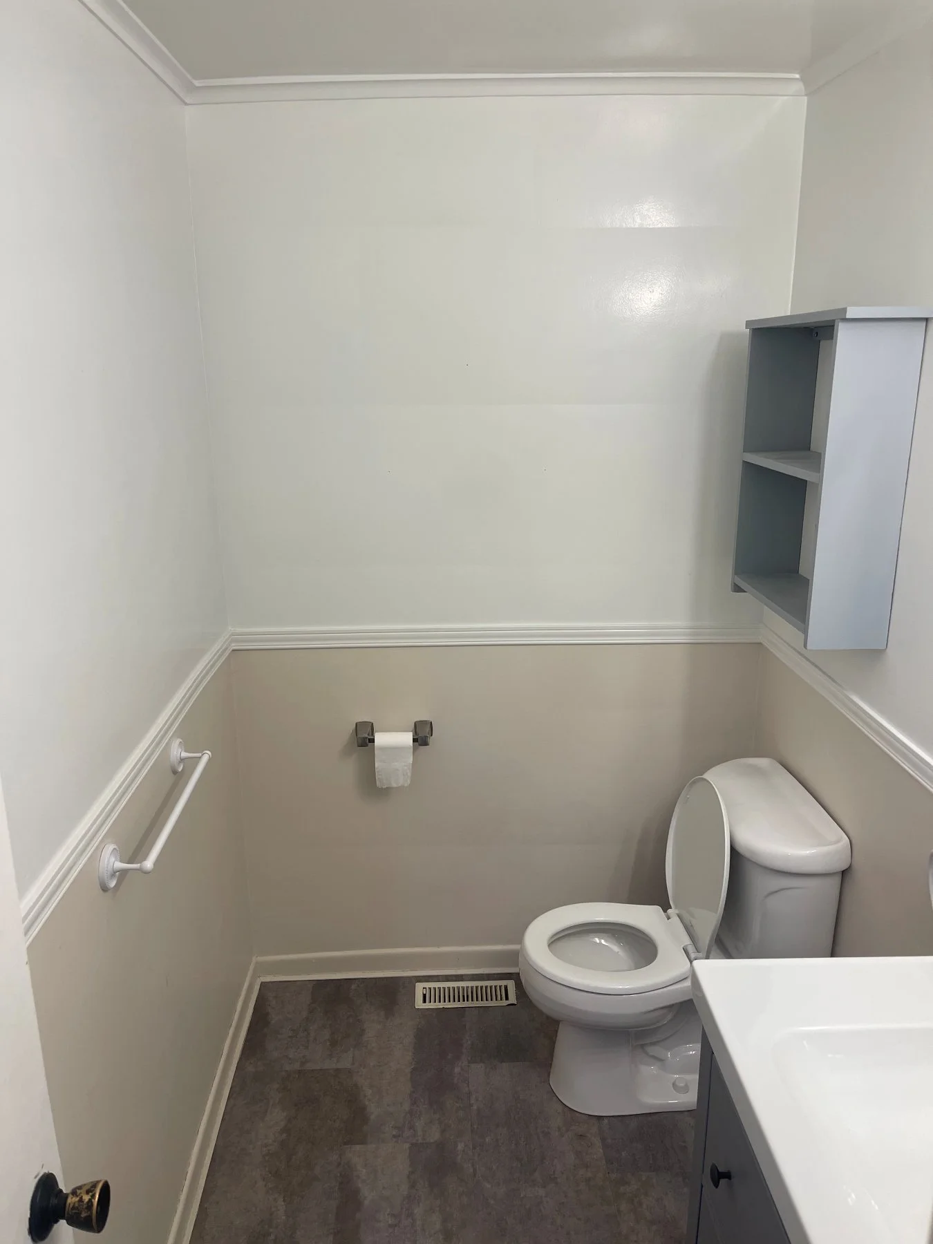 Etobicoke bathroom before the renovation, with vinyl plank flooring, a chair rail and dated fixtures