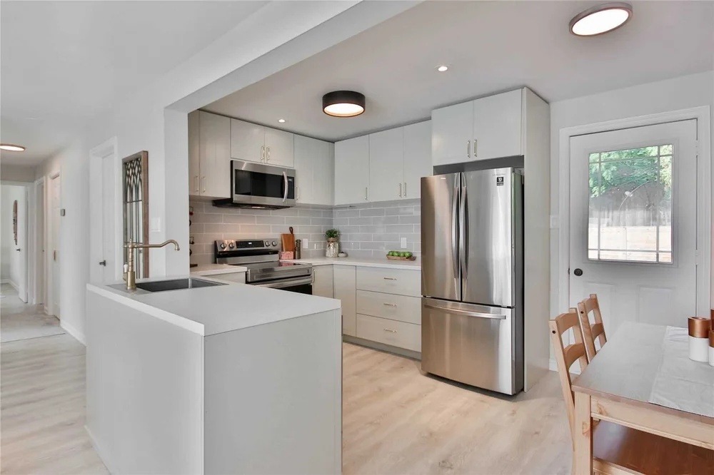 White family kitchen with a large island and stainless appliances