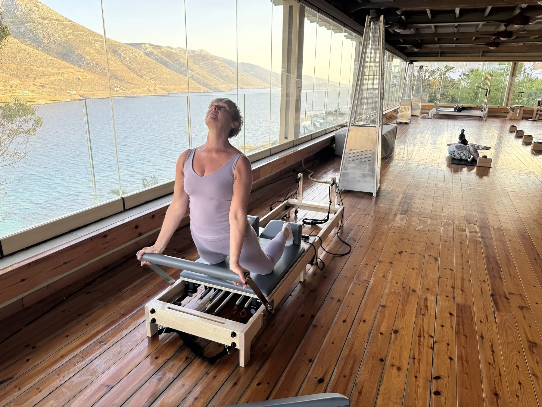 Emma using a Reformer in the sea-facing shala at Aegialis Hotel