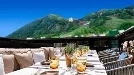Summer dining patio set for dinner below Aspen Mountain