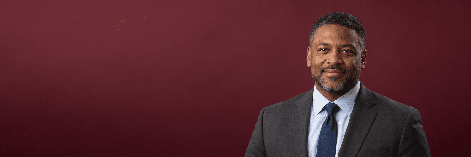 Law firm headshot on a maroon backdrop, photographed by Brett Harkness