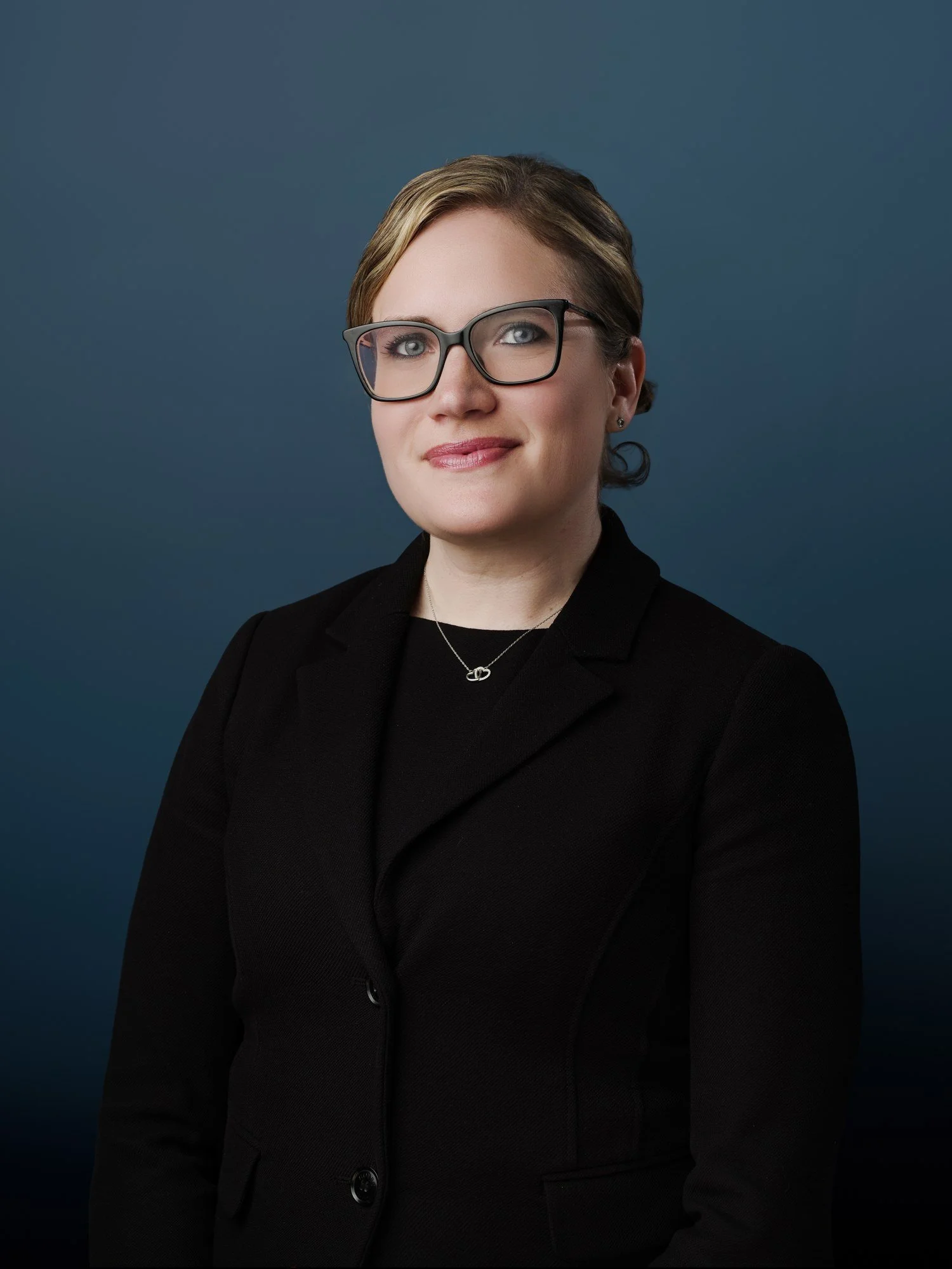 Barrister headshot on a navy backdrop, photographed on site by Brett Harkness