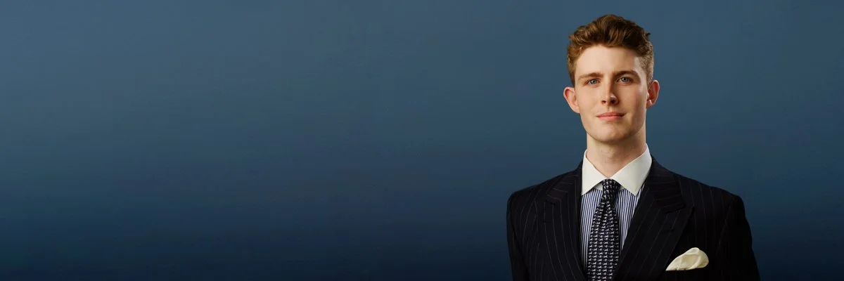 Law firm headshot on a navy backdrop, photographed by Brett Harkness