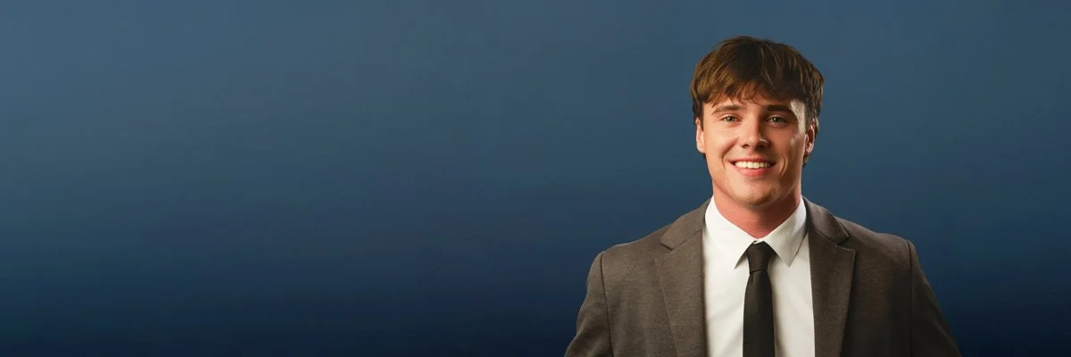 Law firm headshot on a navy backdrop, photographed by Brett Harkness