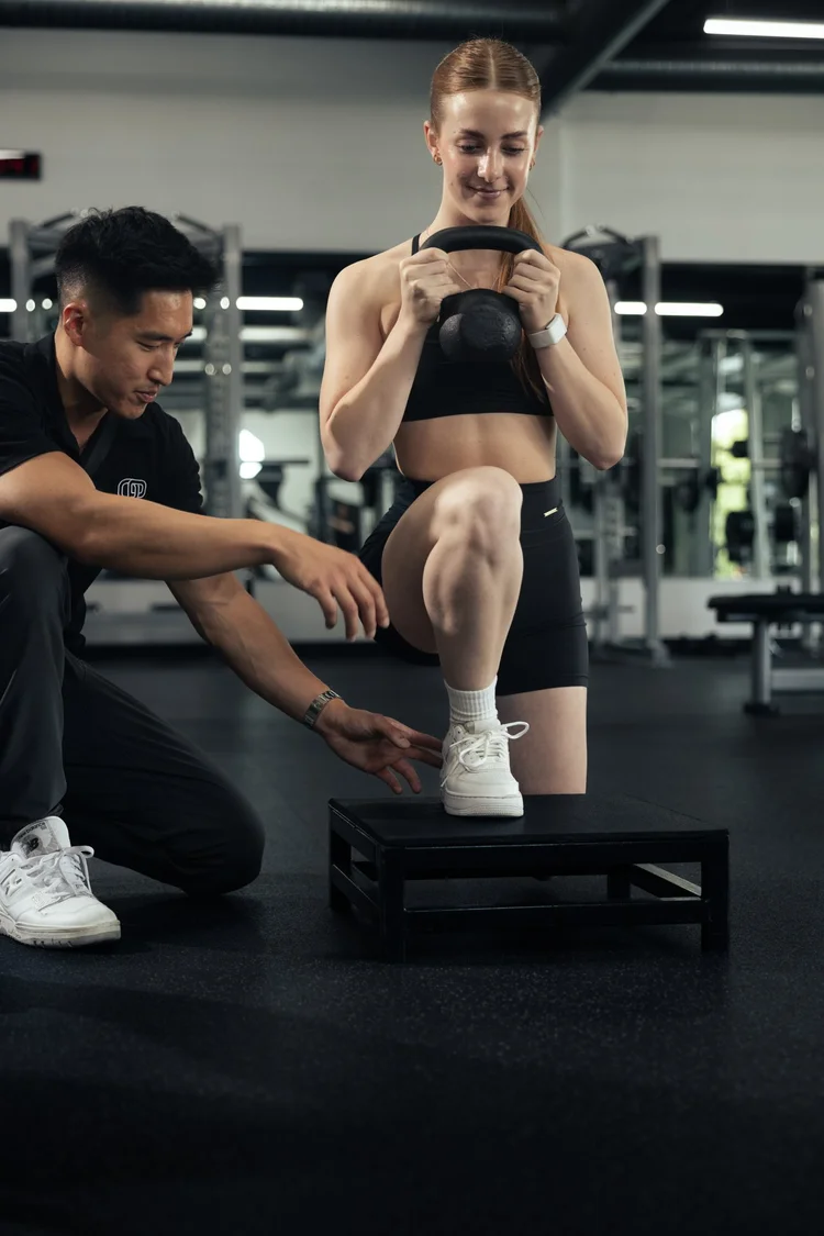 Women's kettlebell goblet step-up coaching with controlled progressions at Crown Fitness Irvine
