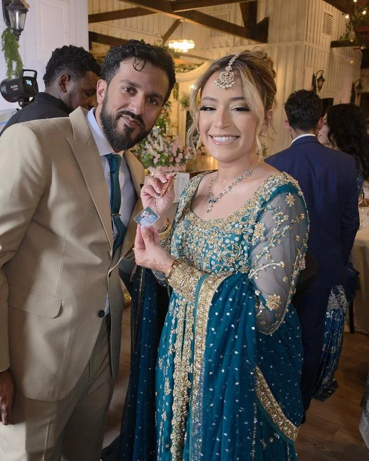 A bride and groom holding up their photo keychain