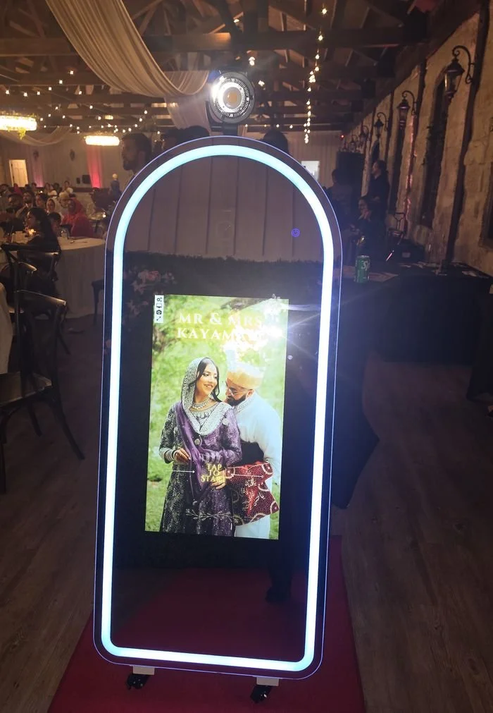 The full-length mirror photo booth glowing at a wedding