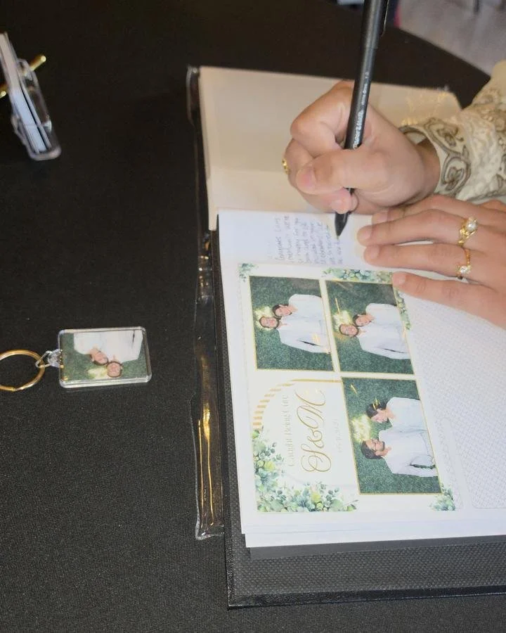 A finished photo keychain next to the keepsake album at a wedding
