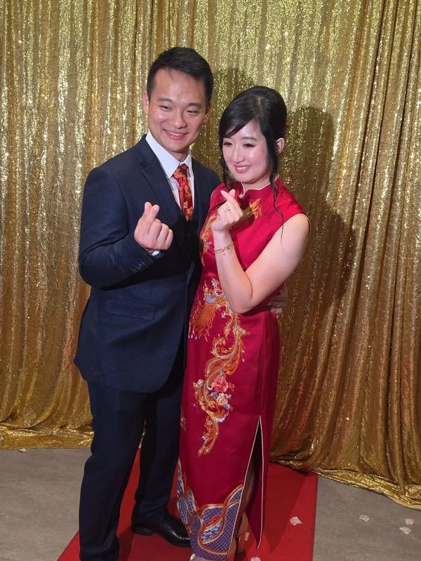 A couple in front of the gold sequin backdrop
