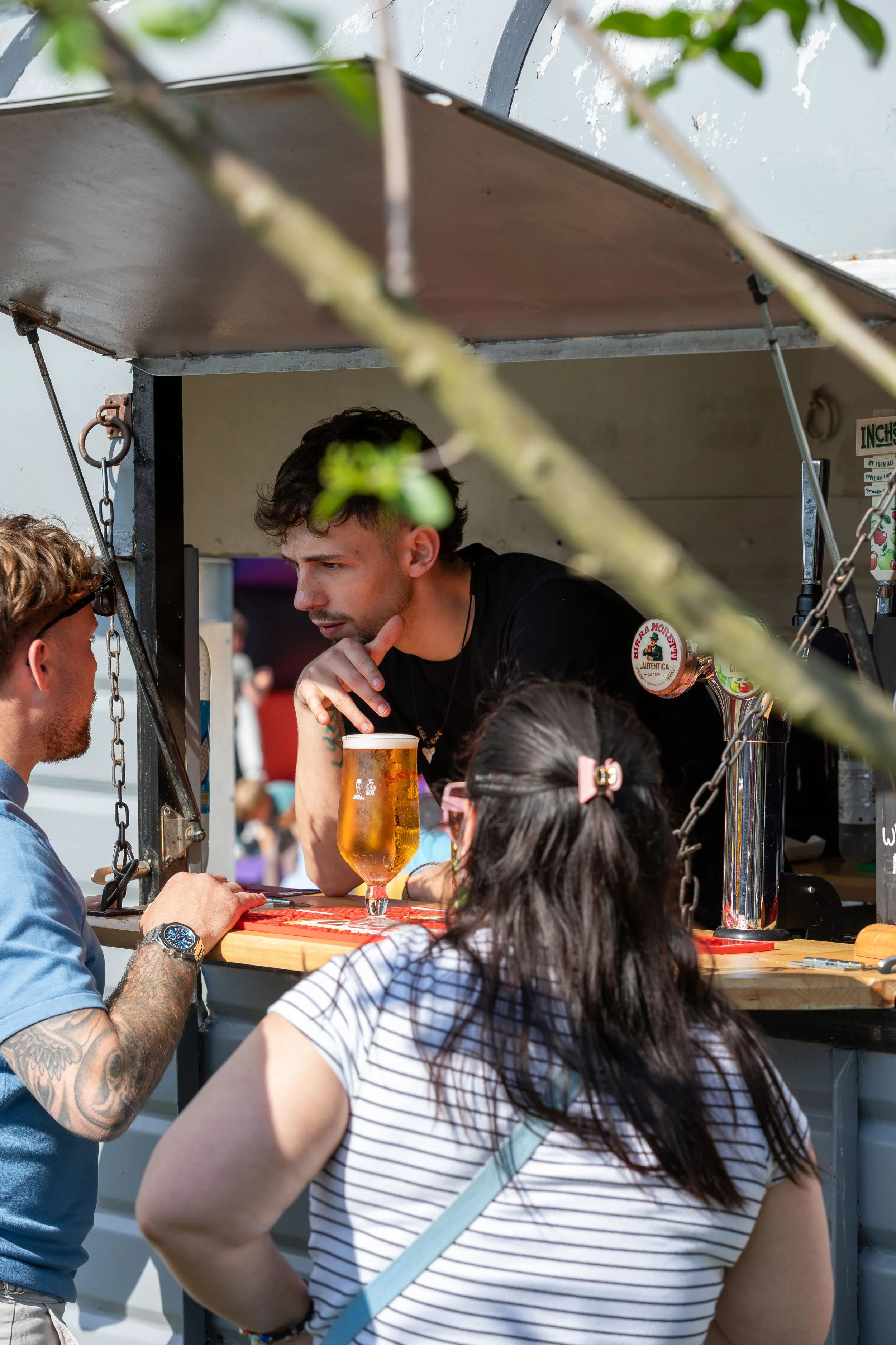 Bartender serving customers from mobile hoursebox bar at The Partridge Inn music festival in Singleton